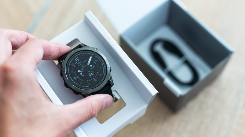 A person taking a Garmin Fenix 7 Sapphire Solar out of the box.