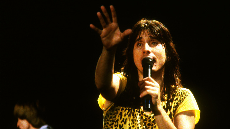 Steve Perry of Journey reaching hand forward while singing in in 1984