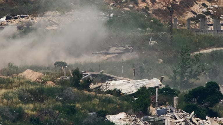 Israeli soldiers drive a tank in southern Lebanon as seen from northern Israel.