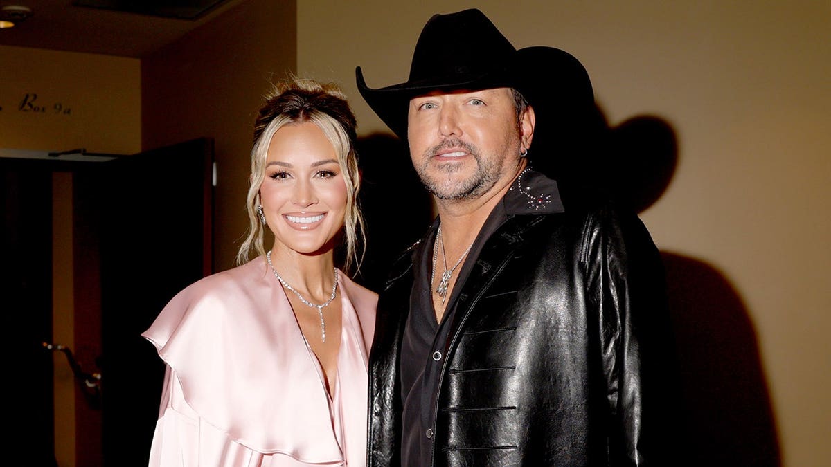 Brittany Aldean and Jason Aldean standing together at the iHeartRadio Music Awards in Los Angeles