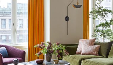 Living room with olive green chaise longue sofa, grey marble coffee tables, purple armchair and orange curtains