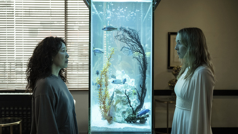 Eve Polastri (Sandra Oh) and Villanelle (Jodie Comer) stare at each other through an aquarium in Killing Eve