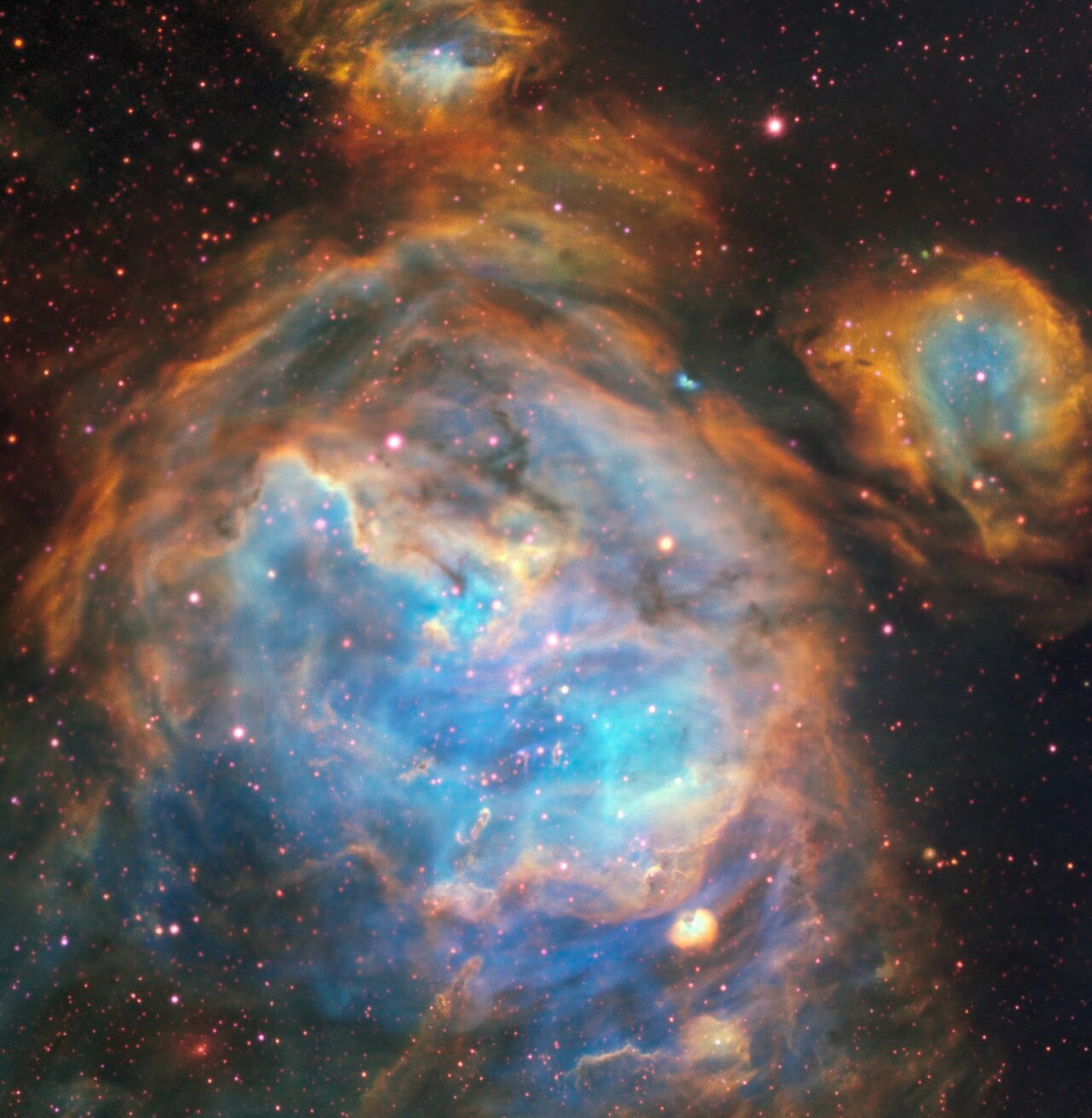 Newborn stars carved out a cavern in this cloud of gas in the Large Magellanic Cloud. Their UV radiation eats away at the gas, sculpting the cavern where they remain. Courtesy: ESO