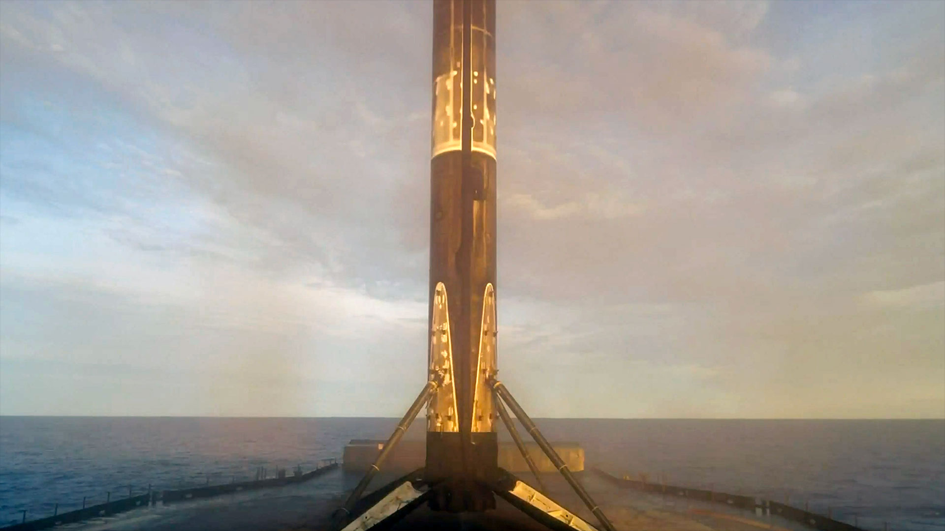 The first stage of an orbital rocket stands on its landing legs atop an ocean-based droneship after landing back from space
