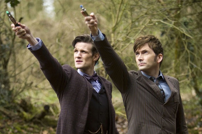 Matt Smith and David Tennant Matt Smith and David Tennant as The Doctor point sonic screwdrivers in the air as they look above at something.