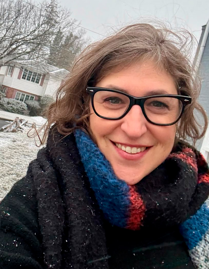 Mayim Bialik smiling outdoors wearing glasses and colorful scarf Mayim Bialik smiling outdoors wearing glasses and colorful scarf