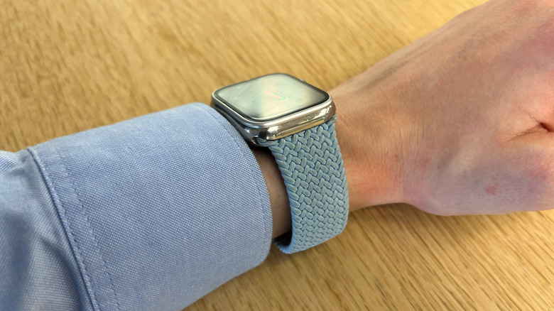 Apple Watch with a light blue fabric band on persons wrist