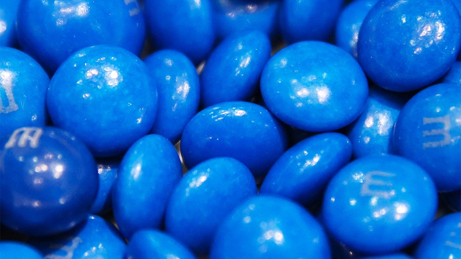 A close-up image shows a bowl of blue M&M's