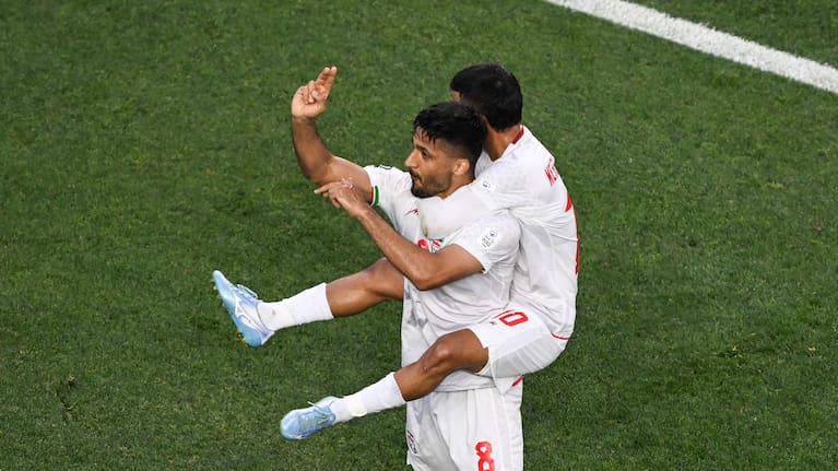 Mohammad Mohebbi of Iran celebrates his goal against New Zealand with Mehdi Ghayedi of Iran.