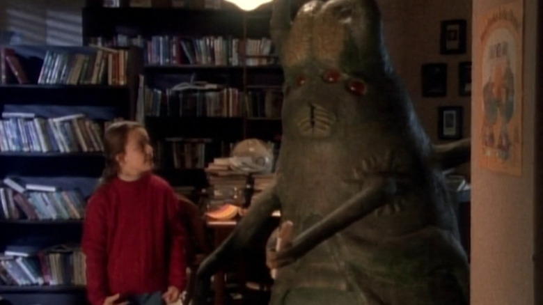 Amy (Jenna von Oÿ) stands next to an insectoid creature in a library in Monsters