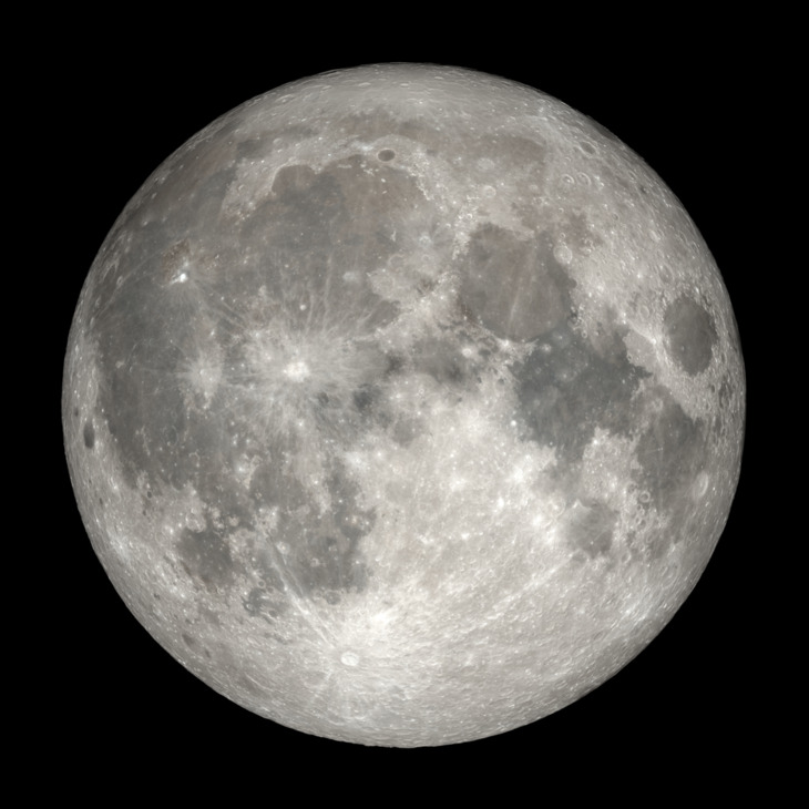 A detailed telescope photograph of a full Moon against a black background. The lunar surface is sharply rendered, showing the contrast between the bright highland regions and the darker maria, along with numerous craters and bright ray systems extending across the disk.