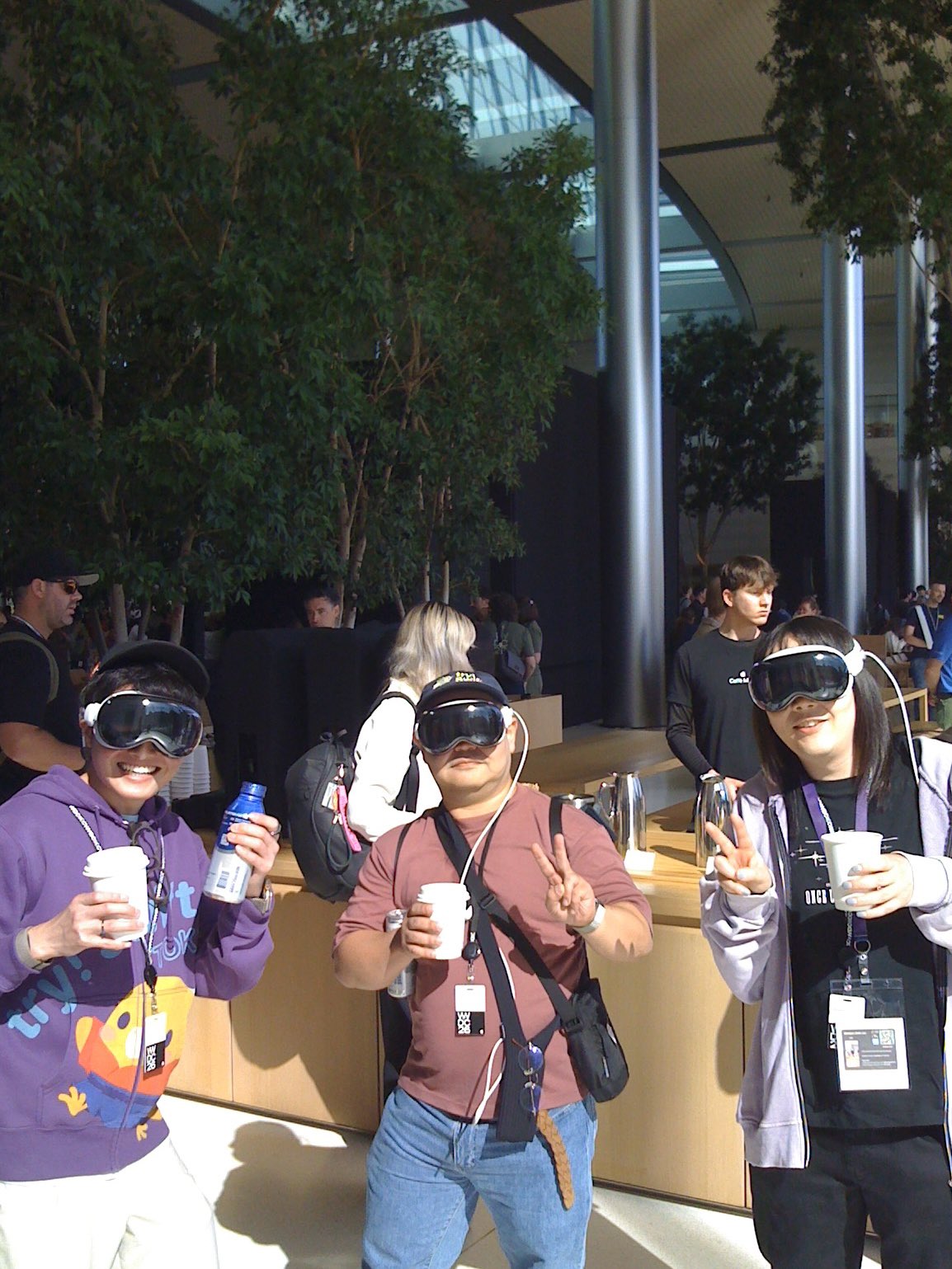 Photo of people wearing Vision Pro headsets, taken on the original iPhone