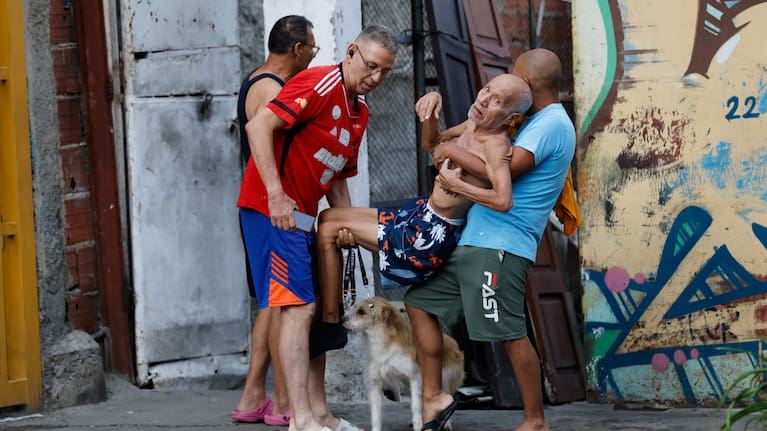 Neighbours helps a man evacuate his damaged home after an earthquake in Caracas, Venezuela.