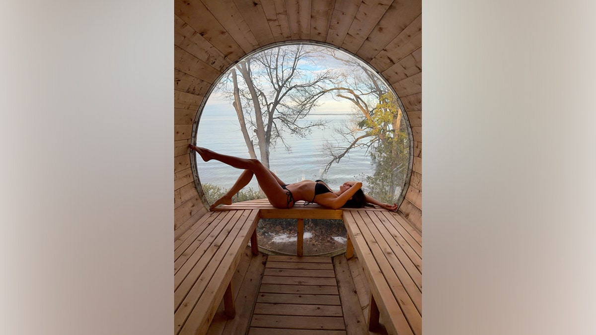 Nina Dobrev posing in a bikini while relaxing at a lakeside location.