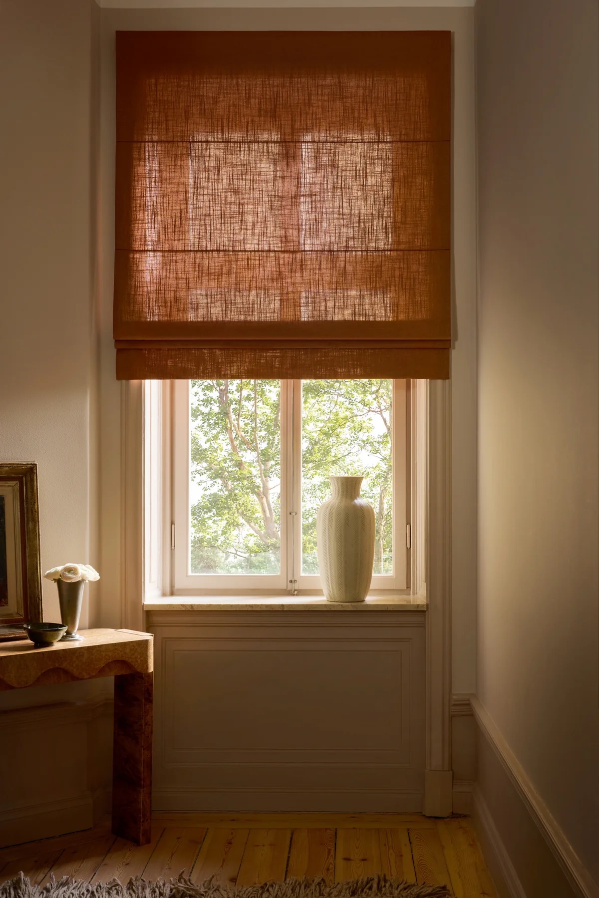 Handmade linen blind and handcrafted vases on windowsill
