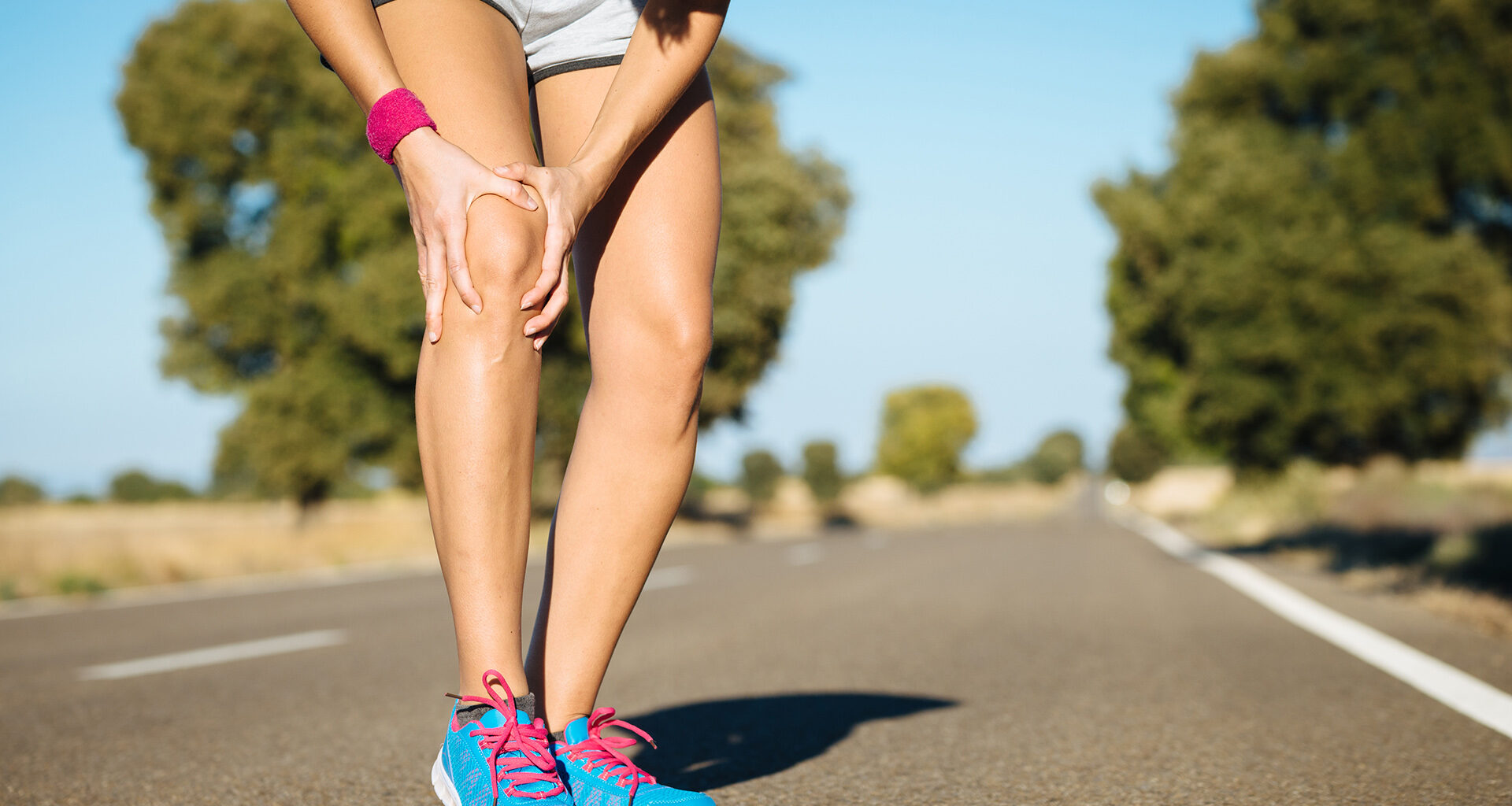 Jogger clutches leg while running.