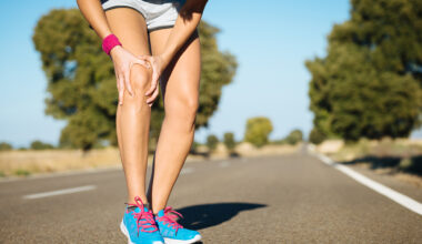 Jogger clutches leg while running.
