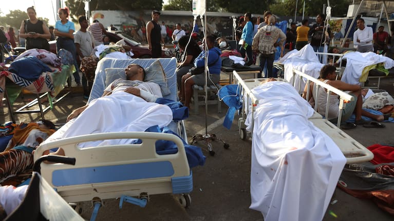 Patients lie outside a hospital evacuated after it was damaged in an earthquake in Catia La Mar, Venezuela.
