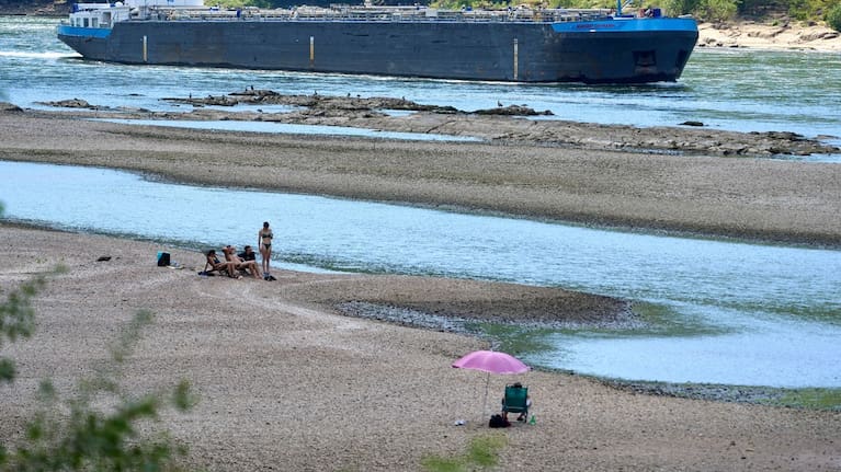 People visit the banks of the Rhine near the Loreley as a cargo ship passes by in Goarshausen, Germany. (Source: Thomas Frey/dpa via AP)