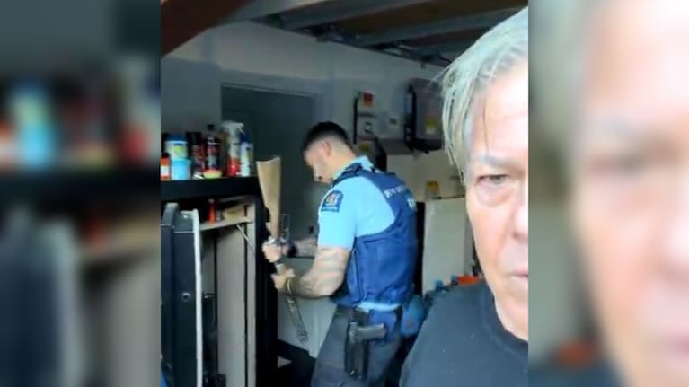 Police pull a gun from Brian Tamaki's gun safe.