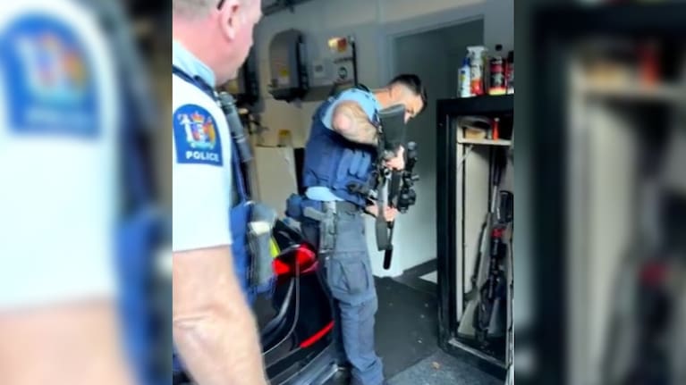 Police pull a gun from Brian Tamaki's gun safe.