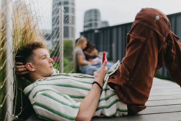 Portrait of young stylish generation Z boy browsing on smartphone. Portrait of young stylish generation Z boy browsing on smartphone.