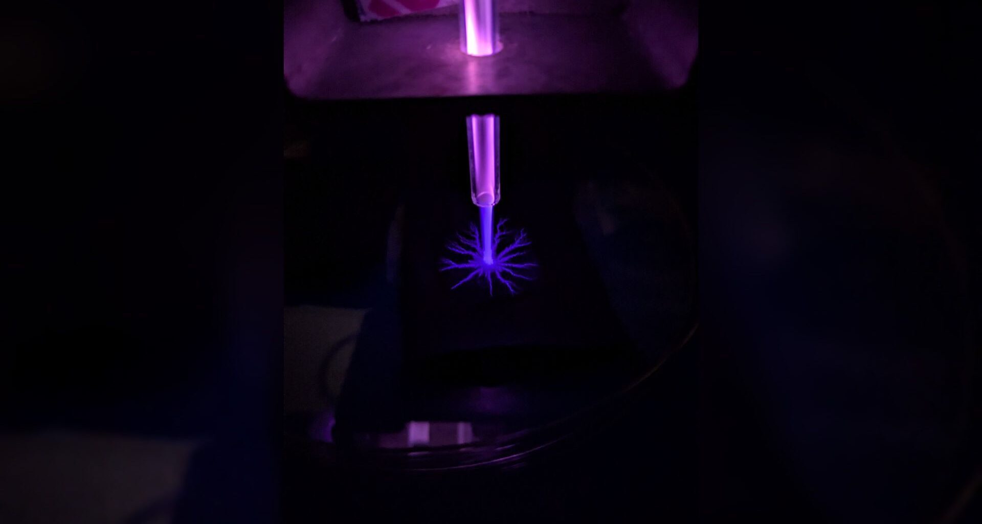 A close up of a blue laser in a dark room.