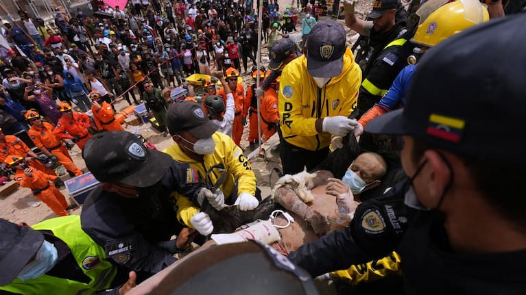 Rescue workers carry a man rescued from the rubble of a building that collapsed in the earthquakes that struck La Guaira, Venezuela.