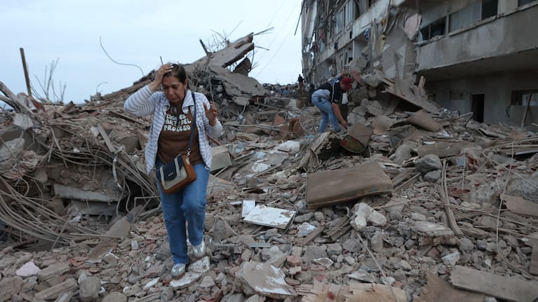Residents walk among the rubble of building damaged in earthquakes the previous day in Catia La Mar, Venezuela.