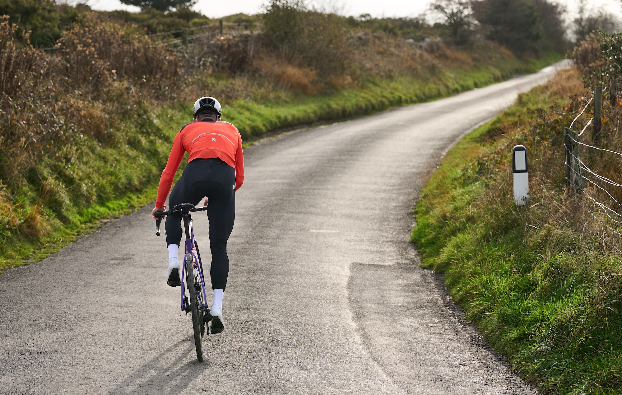 Rider cycling away into the sunset