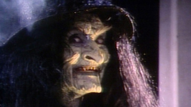 A monstrous witch (Frances Chaney) grins menacingly in Tales from the Darkside