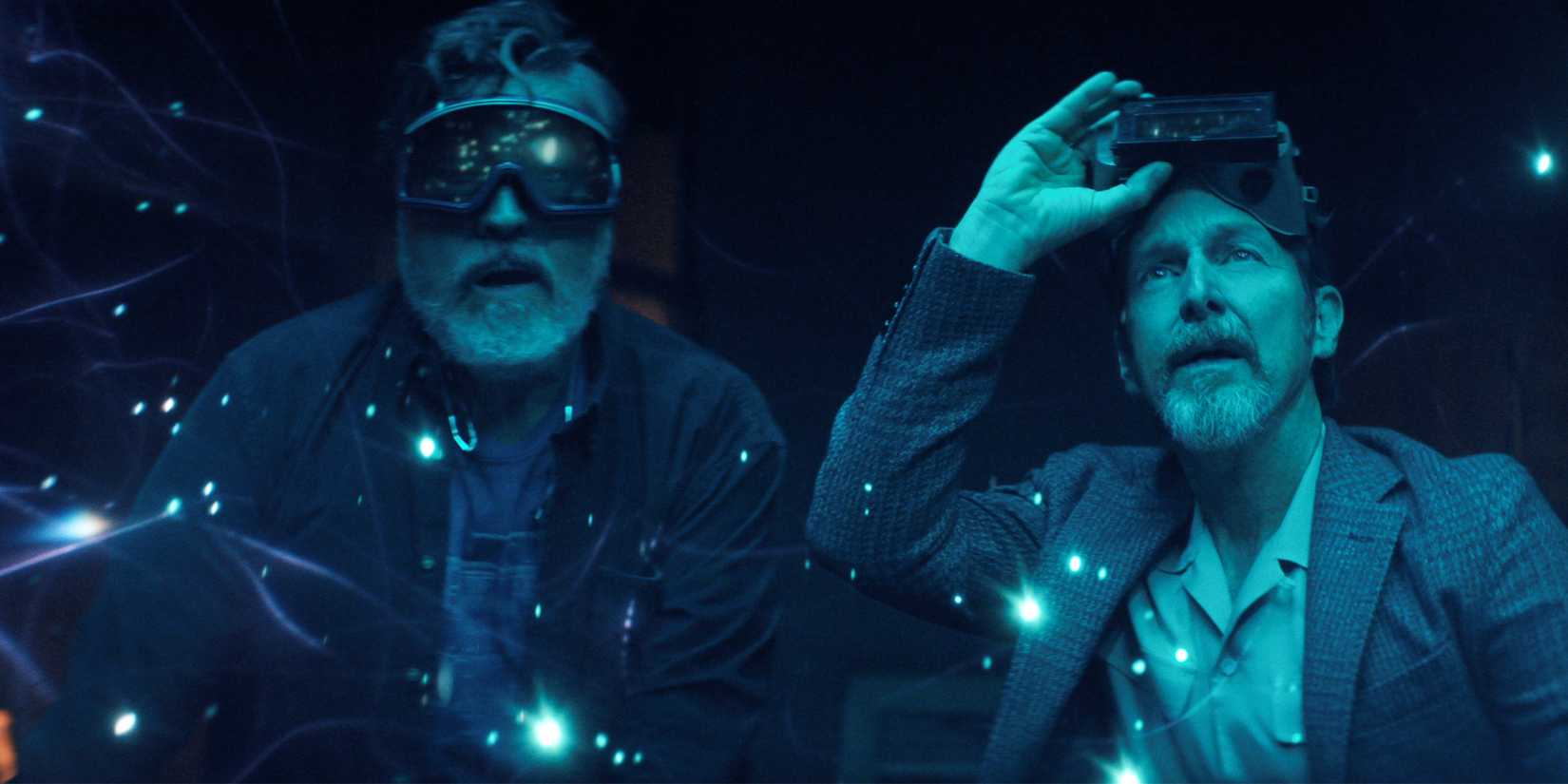 Alfred Molina and Denis O'Hare wear safety goggles and look at suspended lights in midair in The Boroughs