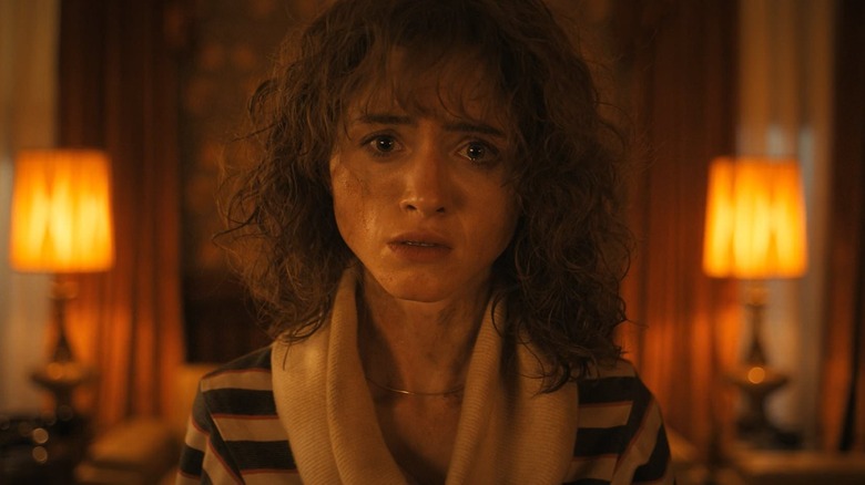 Natalia Dyer as Nancy looking worried in a house in Stranger Things