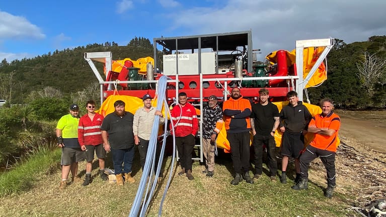 The team at Omākiwi Cove getting the $5m submersible dredge planer ready to go into the water, piping to fix to the ROV's flotation bags stretched out from the stern of the vessel.