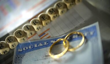 Two wedding rings lie on a Social Security card beside a string of beads that spells "retirement."