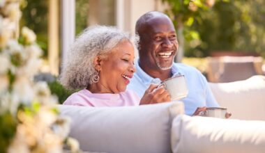 Smiling couple sipping coffee on patio.