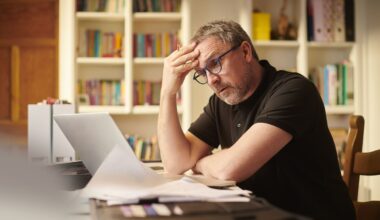 A stressed retiree is staring at a laptop screen.