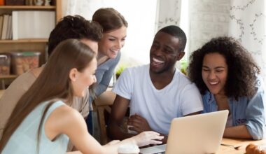 Investors gather around a laptop to look at something.