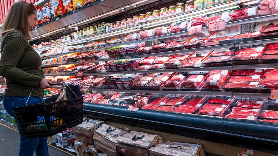 Woman shops for meat at grocery store