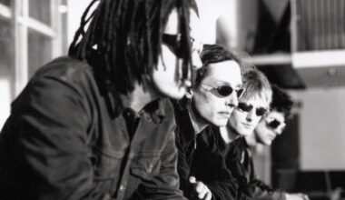 A portrait of Swervedriver in 1998. The band are sat down and all wearing sunglasses