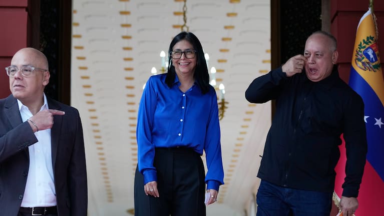 Venezuela's acting President Delcy Rodriguez, center, smiles flanked by Interior Minister Diosdado Cabello, right, and National Assembly President, her brother, Jorge Rodriguez
