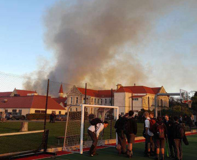 Smoke rises over Waitaki Boys' High School from a nearby vegetation fire this morning. Photo:...