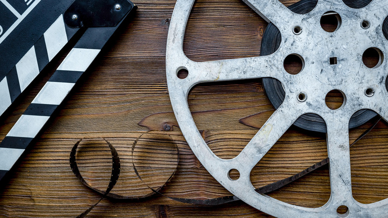 A film reel and clapperboard on a wooden surface