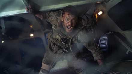 81 (Alan Ritchson) shouts inside an armored transport in a still from Netflix's War Machine