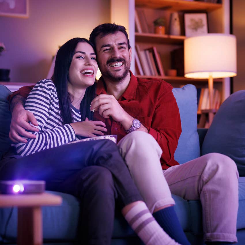 couple laughing while watching a sitcom