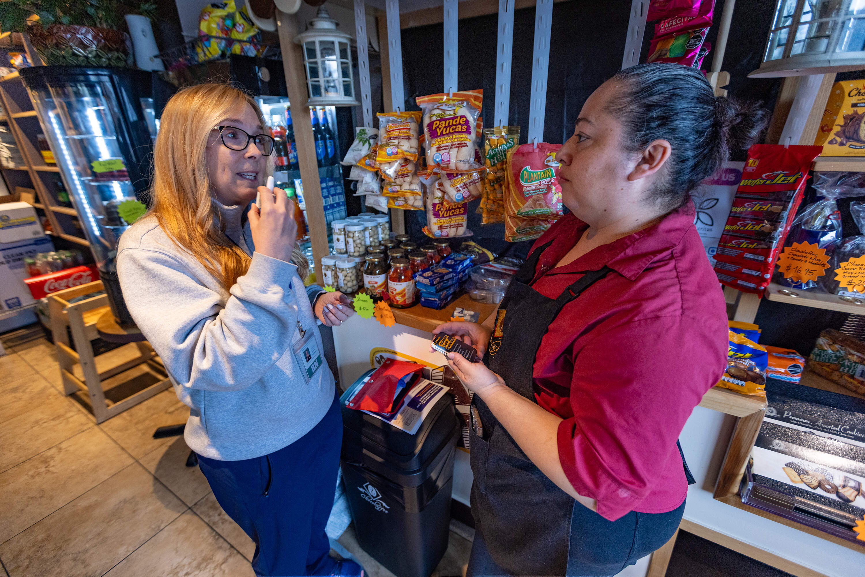 Registered nurse Denise Hartley, co-founder of Atlantic Hill Nursing and Wellness, demonstrates to cafe owner Diana Cardona how to administer naloxone. (Jesse Costa/WBUR)