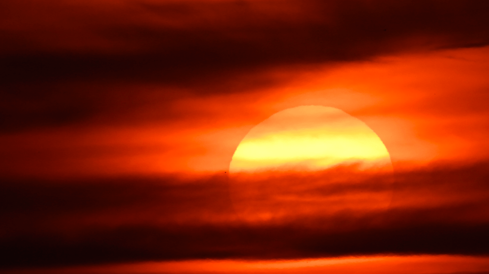 The bright yellow sun gets blocked by dark orange clouds.