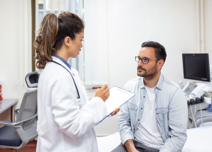A medical worker consulting with a patient in a hospital examination room, revealing a hidden side of hospitals.