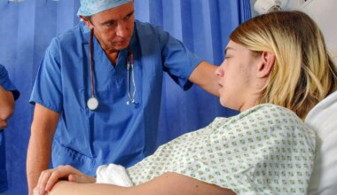 A doctor in hospital bedside consultation with a young male patient.