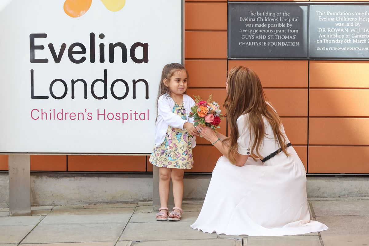 The Princess handing a bouquet of flowers to a young girl